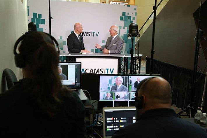 Two business men being broadcast speaking on ACAMS TV