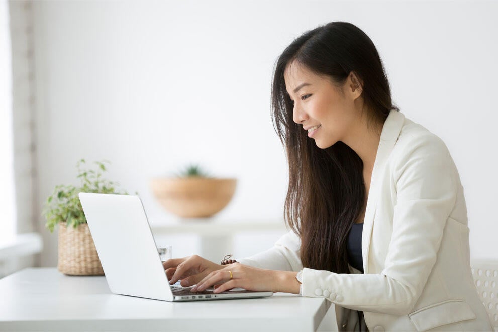 Woman working in laptop and smiling