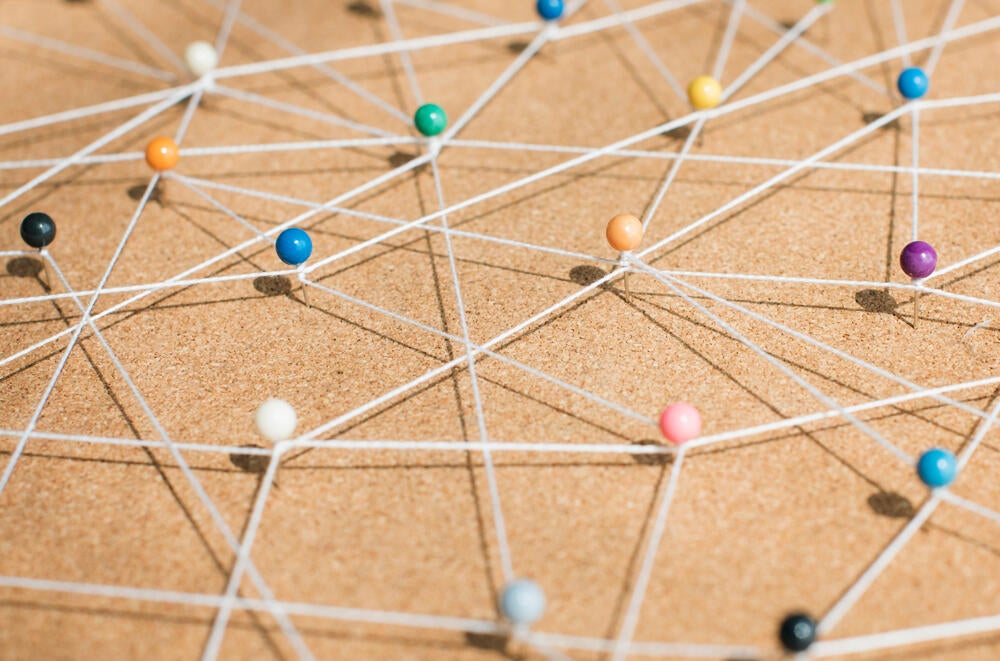 Connecting dots on a cork board with yarn
