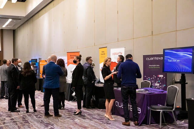 FinTech Conference Recap Photo - Attendees conversing at a booth