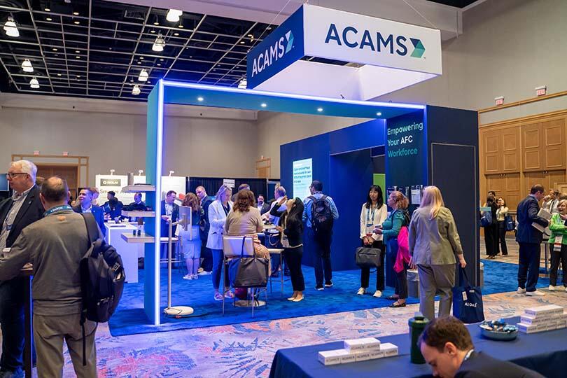 ACAMS Hollywood attendees engaging in conversation at the ACAMS booth
