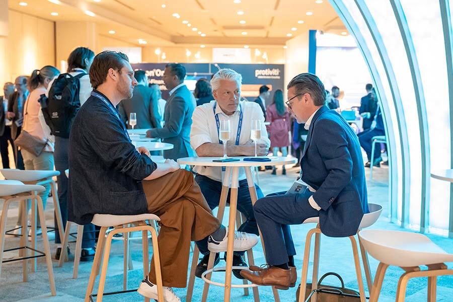 Three attendees conversing at the Assembly Europe